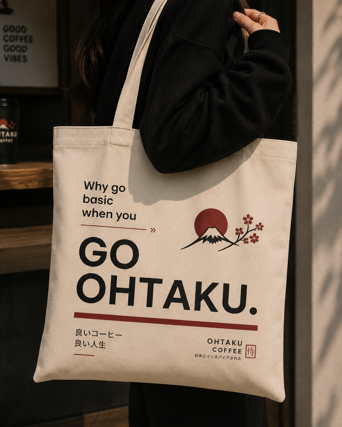 Person holding a tote bag with 'GO OHTAKU' branding and design.